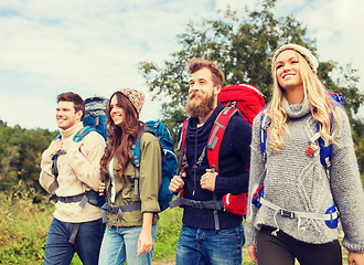 Image showing group of smiling friends with backpacks hiking