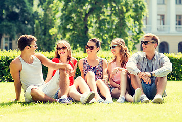 Image showing group of smiling friends outdoors sitting on grass