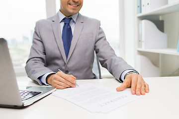 Image showing close up of businessman with laptop and papers