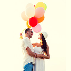 Image showing smiling couple with air balloons outdoors