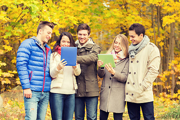 Image showing group of smiling friends with tablets in park