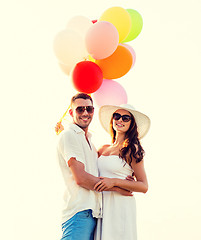 Image showing smiling couple with air balloons outdoors