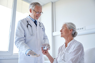 Image showing doctor giving medicine to senior woman at hospital