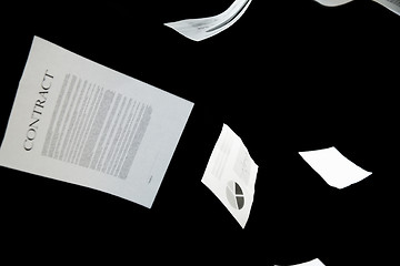 Image showing business papers falling down over black background