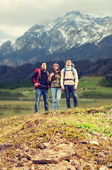 Image showing group of smiling friends with backpacks hiking