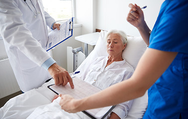 Image showing doctor and nurse visiting senior woman at hospital