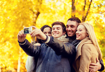 Image showing group of smiling men and women making selfie