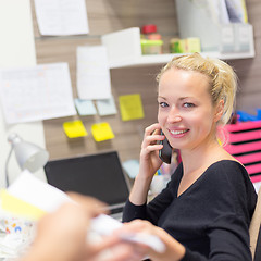 Image showing Businesswoman talking on mobile phone in office.