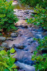 Image showing river stream flowing over rock formations in the mountains