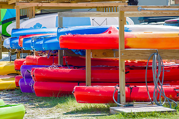 Image showing set of kayaks laying on sandy beach on sunny day