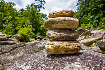 Image showing Stack of round smooth stones near mountain river