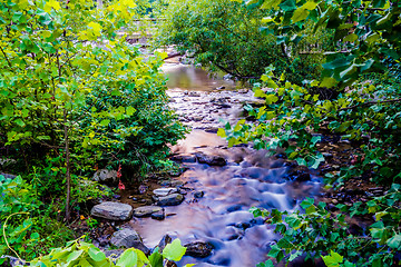 Image showing river stream flowing over rock formations in the mountains