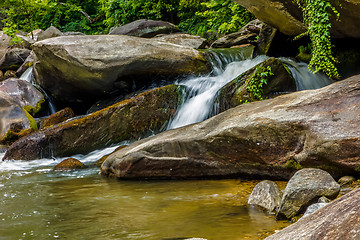 Image showing river stream flowing over rock formations in the mountains