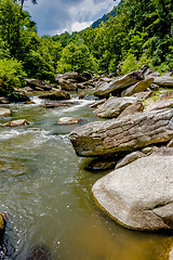 Image showing river stream flowing over rock formations in the mountains