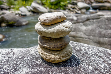 Image showing Stack of round smooth stones near mountain river