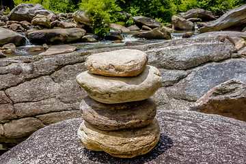 Image showing Stack of round smooth stones near mountain river