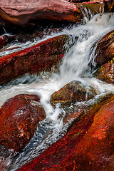 Image showing river stream flowing over rock formations in the mountains