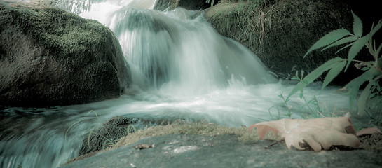 Image showing river stream flowing over rock formations in the mountains