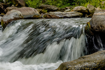 Image showing river stream flowing over rock formations in the mountains