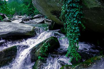 Image showing river stream flowing over rock formations in the mountains