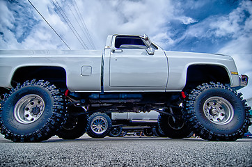 Image showing huge truck with huge wheels at a classic car show in a small tow