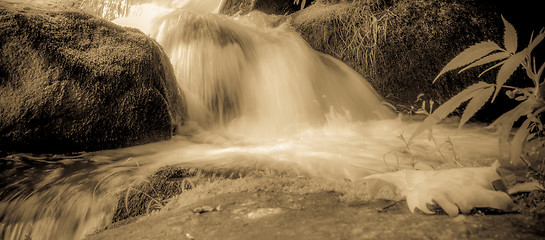 Image showing river stream flowing over rock formations in the mountains