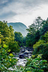 Image showing river stream flowing over rock formations in the mountains