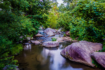 Image showing river stream flowing over rock formations in the mountains