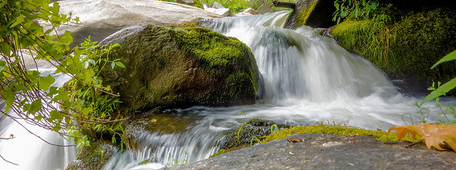 Image showing river stream flowing over rock formations in the mountains