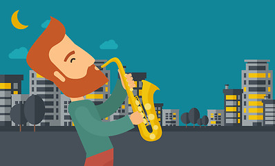 Image showing Saxophonist playing in the streets at night