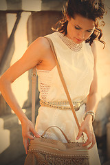 Image showing woman in a white dress corrects handbag