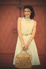 Image showing Smiling beautiful middle-aged woman in a white dress