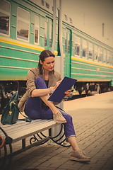 Image showing beautiful adult woman takes notes in notepad