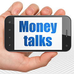 Image showing Finance concept: Hand Holding Smartphone with Money Talks on display