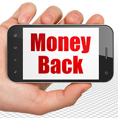 Image showing Business concept: Hand Holding Smartphone with Money Back on display