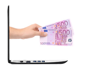 Image showing hand with money comes from laptop screen isolated on white