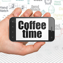 Image showing Timeline concept: Hand Holding Smartphone with Coffee Time on display