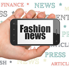 Image showing News concept: Hand Holding Smartphone with Fashion News on display