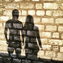 Image showing Shadows of man and woman on a brick wall