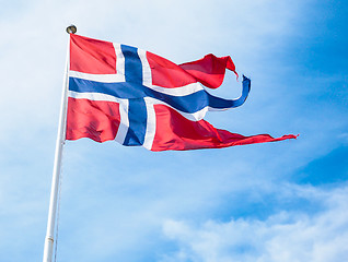 Image showing The Royal flag of Norway on a pole towards blue and white sky in