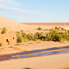 Image showing sunset in africa old construction near the river blue