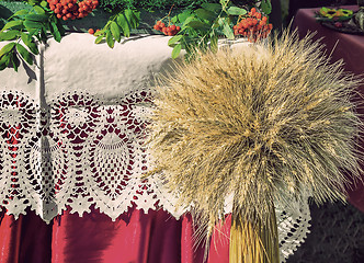 Image showing A sheaf of wheat on a background of lace fabric.
