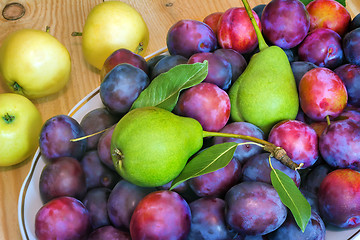 Image showing Fruit in a ceramic dish on a wooden table.