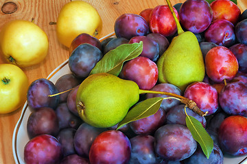 Image showing Fruit in a ceramic dish on a wooden table.