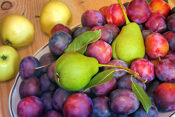 Image showing Fruit in a ceramic dish on a wooden table.