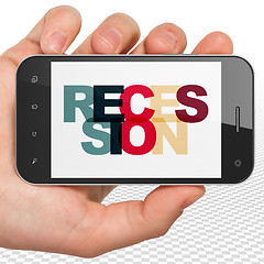 Image showing Finance concept: Hand Holding Smartphone with Recession on  display