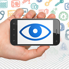 Image showing Protection concept: Hand Holding Smartphone with Eye on display