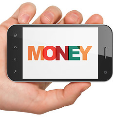 Image showing Currency concept: Hand Holding Smartphone with Money on  display