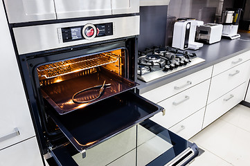 Image showing Modern hi-tek kitchen, oven with open door