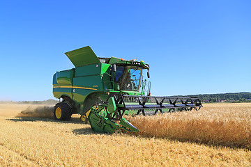 Image showing John Deere Combine s670i Harvests Barley on a Sunny Day